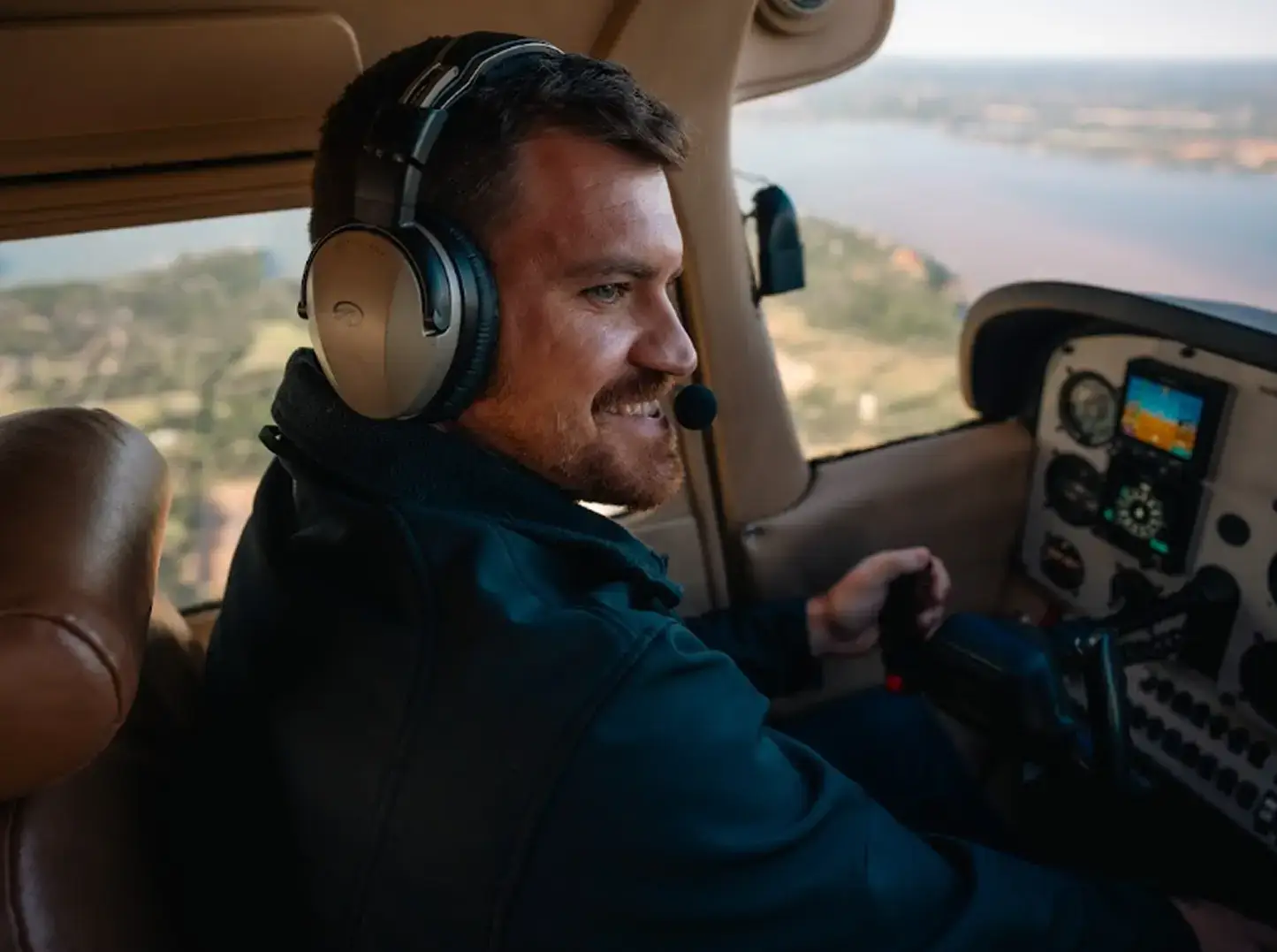 Student pilot smiling confidently while seated in the cockpit of a Cessna 172