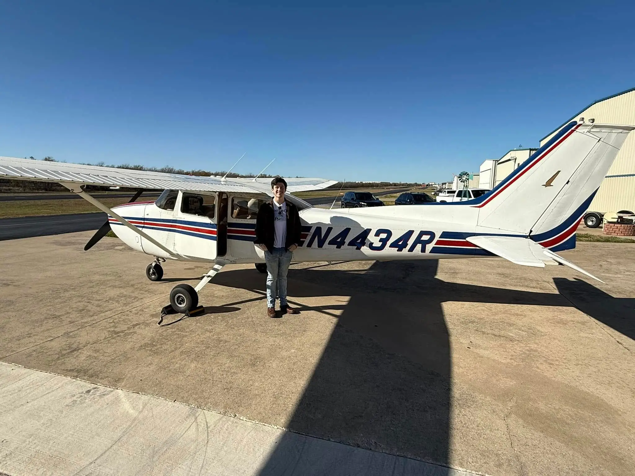 Student on a sunny day next to a Cessna 172 at Bird Dog Flight Services